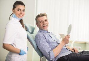 gentleman in dental chair with hygienist standing behind him